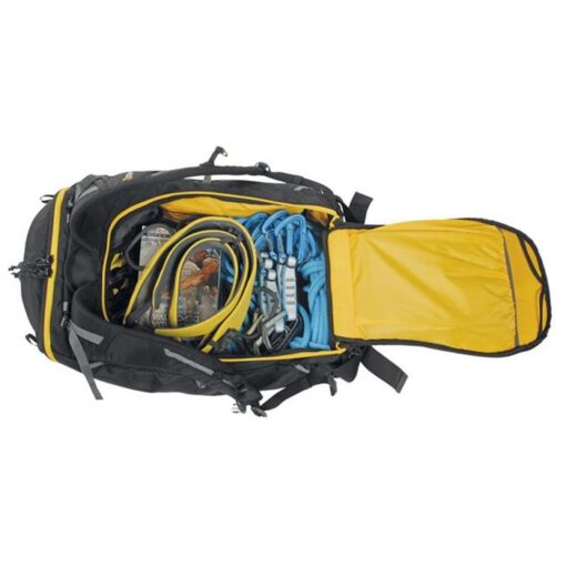 Das Bild zeigt einen geöffneten Climbing Pack mit allerlei Kletterausrüstung darin. Der Kletterrucksack liegt waagrecht im unteren Bildteil, mit dem geöffneten Deckel rechts.